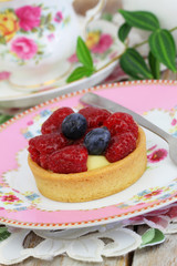 Delicious crunchy cream cake with fresh raspberries and blueberries
