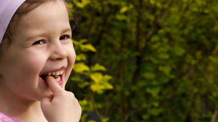 Ein kleines Mädchen leckt Schokocreme von ihrem Finger und lacht - Teil 1