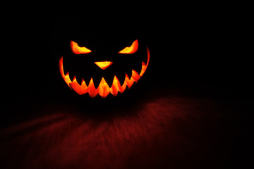 spooky pumpkin Halloween with fire light on black background
