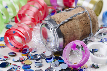 Confetti, streamers and champagne cork on a white background