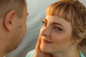 Romantic couple standing and kissing on background summer lake  sunset