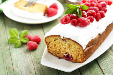 Raspberry cake on plate on green wooden background