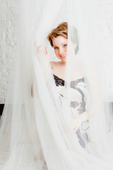 Cheerful woman sitting in bed and  looking at camera © OlgaKhorkova