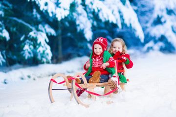 Kids having fun on a sleigh ride in winter
