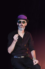 Bearded man with a cigarette wearing a hat and sunglasses