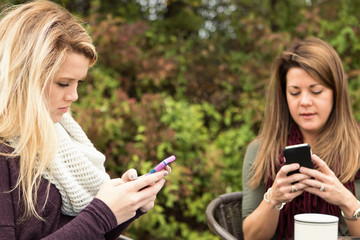 Mother and teenage daughter not spending time together and text messaging. 