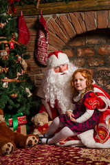 Santa Claus sitting with a little girl.