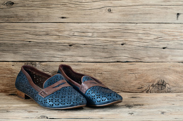 Naklejka premium Women's shoes on a wooden background closeup