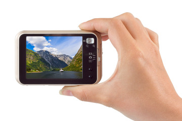 Hand with camera and Norway travel photo