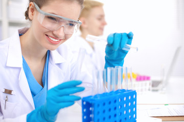Woman researcher is surrounded by medical vials and flasks, isolated on white background