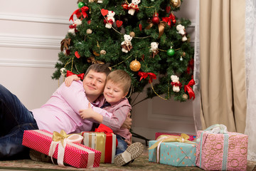 Obraz na płótnie Canvas Father and son hugging next to Christmas tree. new year