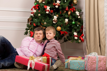 Obraz na płótnie Canvas Father and son near the tree. Christmas