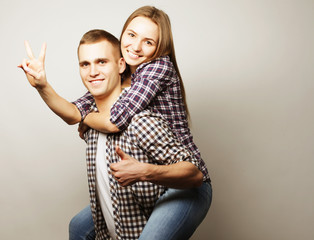 young man carrying girlfriend on his back.