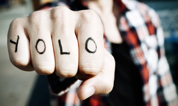 young man with the word yolo in his knuckles, filtered