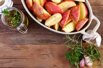 wedges uncooked with olive oil can and garlic and herb shot from above on wooden boards landscape