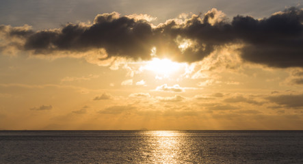 sunset over the sea with the sun rays through the clouds