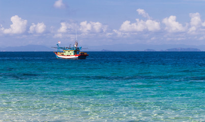 blue sea and a small fishing boat.