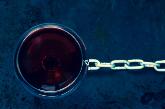 Glass of red wine with a steel chain