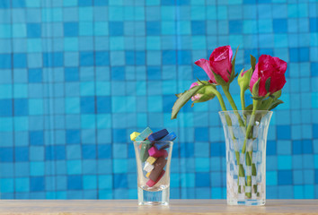 Stock Photo:.Bunch of pink roses in vase with pink gift and blan