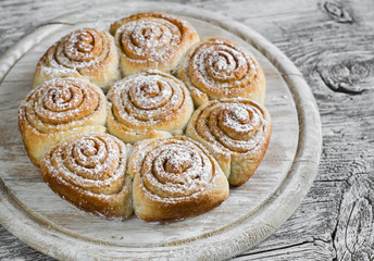 cinnamon rolls on bright wooden surface