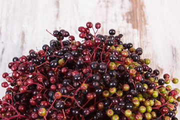 Bunch of fresh elderberry on old wooden background, healthy food