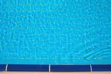 Ripples and reflections in water of summer swimming pool