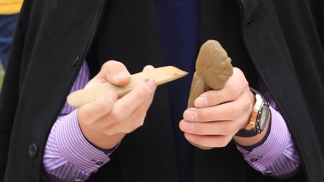 craftsman making a doll from clay