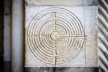 Ancient Labyrinth. Curious stone placed on San Martino Cathedral in Lucca, Tuscany, Italy. - obrazy, fototapety, plakaty