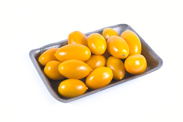 Ripe yellow tomatoes in grey plastic container isolated on white