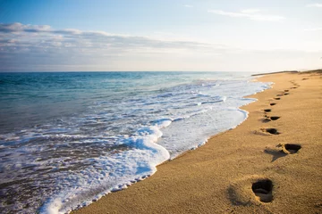 Gartenposter Strand und Meer Nahaufnahme von Fußabdrücken im Sand bei Sonnenuntergang