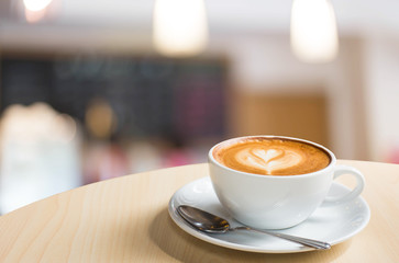 Hot art Latte Coffee in a cup on wooden table and Coffee shop bl
