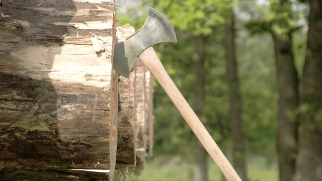 Three axes thrown on a circle log. The axe are flying as part of the axe throwing competition
