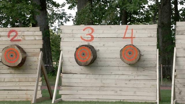 Four big logs on a wall for a competition. These logs are numbered from 1-4 for an axe throwing event