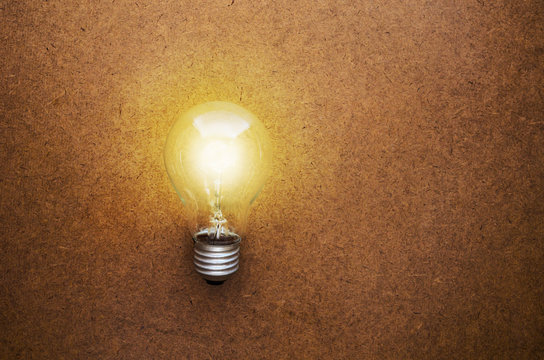 glowing bulb on the brown wooden background