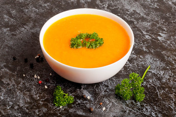 spicy pumpkin soup with parsley in a white saucepan