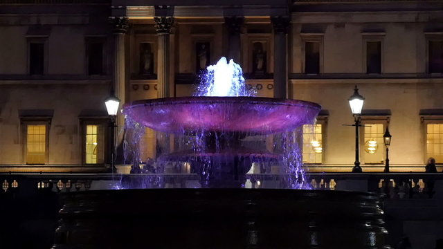The big fountain from the front of the gallery in London. The footage is taken at night with the purple lights on the fountain