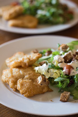 Fried fish with Caesar salad.