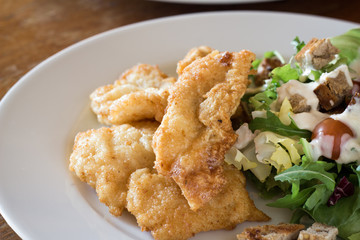 Fried fish with Caesar salad.