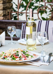 Caesar chicken salad with grated parmesan served with white wine