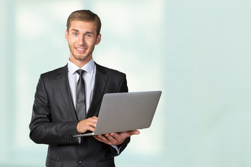 Young handsome businessman holding laptop