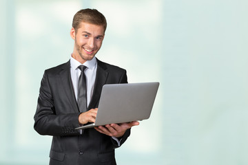 Young handsome businessman holding laptop