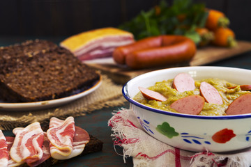 Traditional Dutch pea soup and ingredients on a rustic table