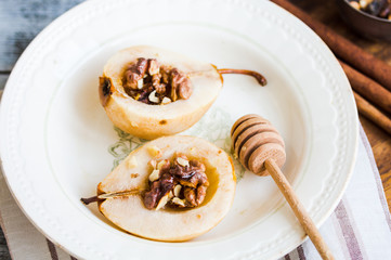 spicy baked pear with walnuts, honey, healthy dessert,close up