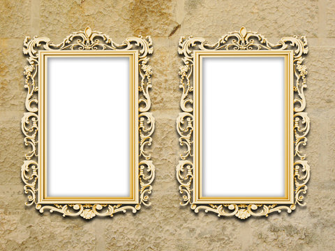 Two golden baroque frames on grungy yellow concrete wall background