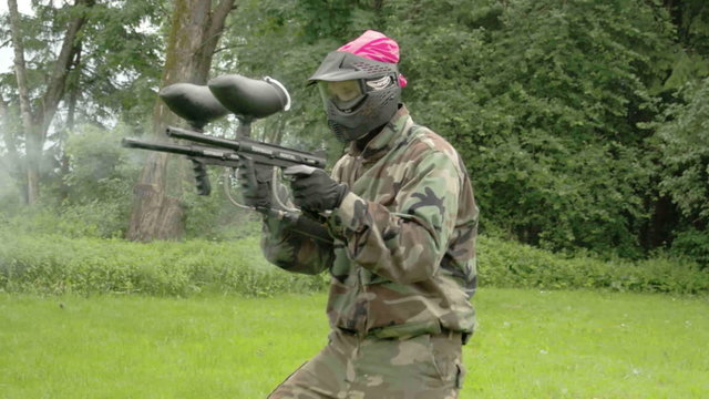 A man holding two guns on paintball. Firing the two guns on the target while walking