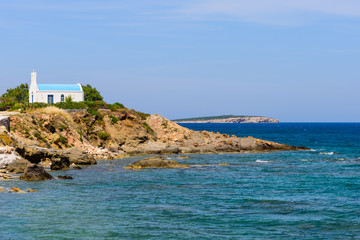 Classic Greek Church on a rocky beach, Paros island, Cyclades, Greece.