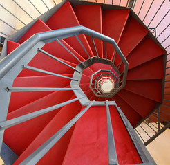spiral staircase with red carpet in a modern building
