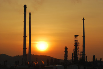 Sunset behind oil refinery plant