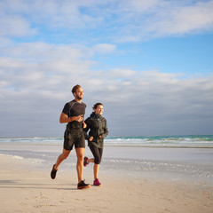 Man and woman running on the beach together