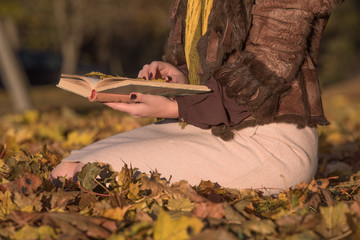 Woman reading in the autumn outdoor